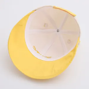 Vista interna di un cappello giallo per bambini con cuciture rinforzate e fodera bianca