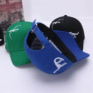 Detailed view of three dinosaur baseball caps in green, blue and black with metal buckle