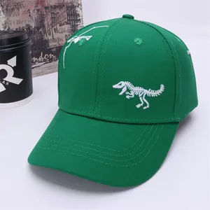 Detail of green cotton baseball cap with white dinosaur skeleton embroidery for boys