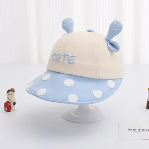 Dettaglio cappello sole bimbo con ricamo CUTE, falda a pois blu e orecchie 3D