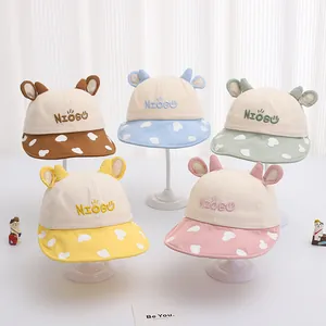 Dettaglio di cinque cappellini estivi in cotone per bambini con tesa a macchie e orecchie