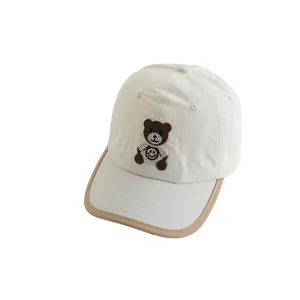 Ademende crème kinderpet met schattige berenborduursel en contrasterende klepdetails