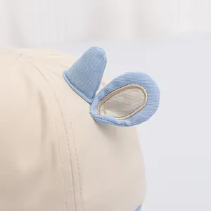 Dettaglio cappello sole neonato con graziose orecchie 3D blu e ricami in cotone di qualità