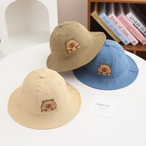 Detailed view of three capybara cartoon bucket hats in khaki blue and beige cotton