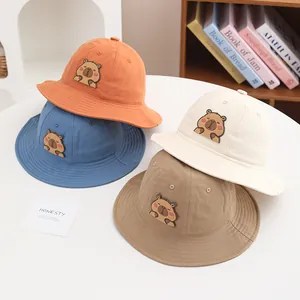 Detail view of four colorful cotton kids bucket hats with cute cartoon bear patches