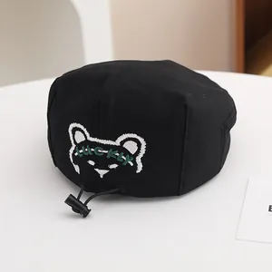 Dettaglio cappello nero per bambini con ricamo orsetto lucky e cordoncino di regolazione