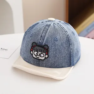 Detailed embroidery of a cartoon girl on a blue denim baseball cap for infants