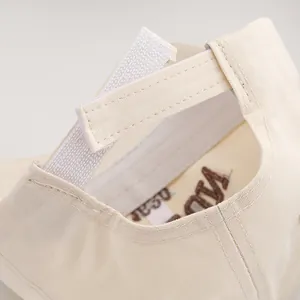 Close-up of beige cotton baseball cap with adjustable Velcro back strap and fine stitching