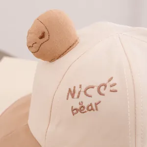 Detail of embroidered NICE bear text and 3D plush bear on baby bucket hat