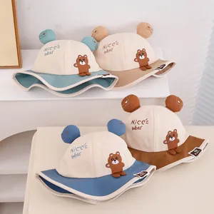 Flat lay of baby sun hats in four colors with bear ears and 'NICE bear' embroidery
