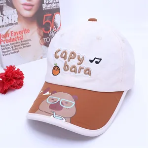 Detail des bestickten Capybara-Logos auf der weiß-braunen Kinder-Baseballkappe