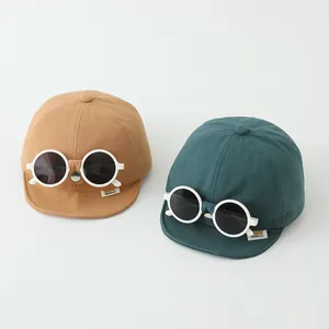 Dettaglio del cappellino creativo per bambini con occhiali tondi e etichetta in tessuto