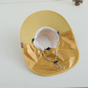 Close-up of yellow sun hat featuring breathable mesh lining and adjustable wind cord detail