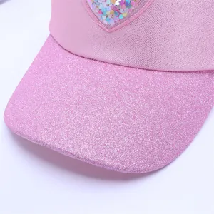 Detail of pink glitter brim and transparent heart pocket with colorful sequins on child hat