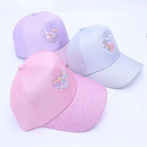Detail of children's glitter baseball caps with heart-shaped sequin window and sparkle finish