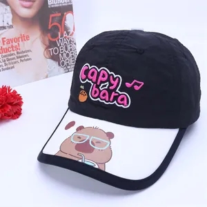 Detail einer Kinder-Baseballkappe mit schwarzer Krone, weißer Krempe und Capybara-Motiv
