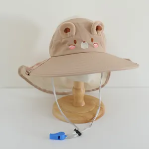Détail d'un chapeau de soleil enfant avec broderie ours, protège-nuque et sifflet bleu