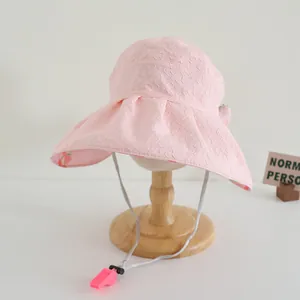 Detail eines rosa Sonnenhuts mit Jacquard-Struktur und verstellbarem Kinnriemen mit Pfeife