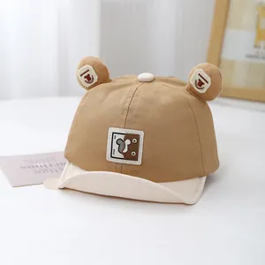Detail of baby baseball cap featuring cartoon bear ears and soft patchwork fabric brim