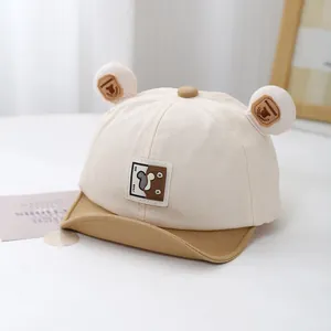 Detail of baby baseball cap with plush ears, bear logo patch and soft contrast visor