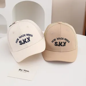 Détail de casquettes bébé en mesh avec broderie SKY et maille respirante au dos