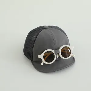 Dettaglio cappellino bimbo con occhiali decorativi e rete nera traspirante