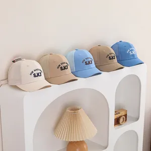 Casquettes de baseball en filet pour enfants avec broderie sur une étagère déco