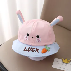 Close-up of pink and blue baby sun hat with cute bunny ears and a lucky carrot detail