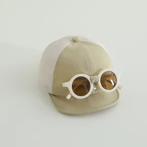 Dettaglio del cappellino per neonati con occhiali decorativi e rete bianca traspirante