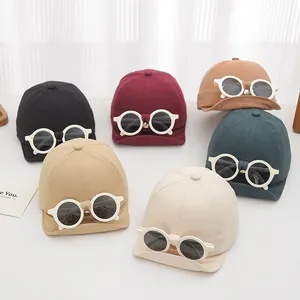 Baby baseball caps in six colors with decorative glasses on a soft white background