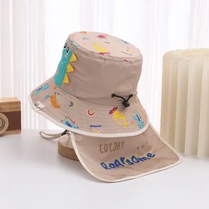 Detail of khaki kids sun hat featuring cartoon dinosaurs and protective neck flap