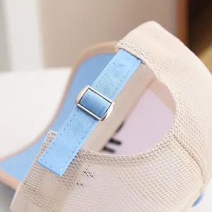 Close-up of adjustable silver metal buckle and light blue strap on a mesh baseball cap