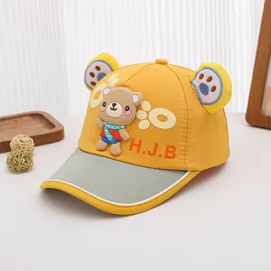 Détail de casquette enfant jaune avec décoration d'ours en 3D et broderie H.J.B