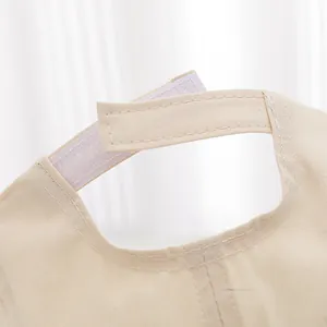 Macro shot of the adjustable velcro strap and cotton twill texture on the beige toddler cap