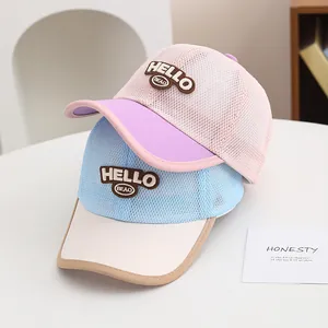 Close-up of kids mesh baseball caps with HELLO embroidery in pink and blue colors