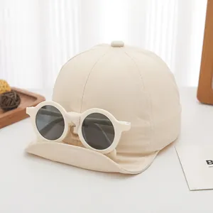 Close-up of beige baby baseball cap with unique detachable round sunglasses decoration