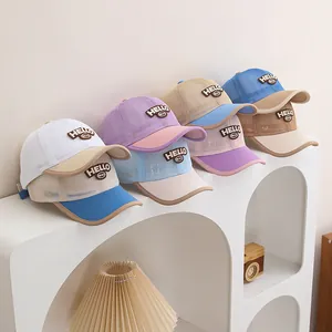 Close-up of assorted breathable mesh baseball caps for kids with HELLO letter patches