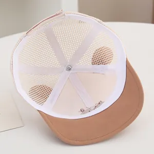 Detail of baby mesh cap showing adjustable velcro strap and cute bear embroidery on brim
