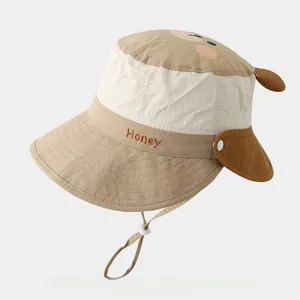 Detailed view of kids sun hat with bear ears, 'Honey' embroidery and windproof strap