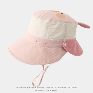 Detail of pink and beige kids sun hat with neck protection flap and adjustable wind cord