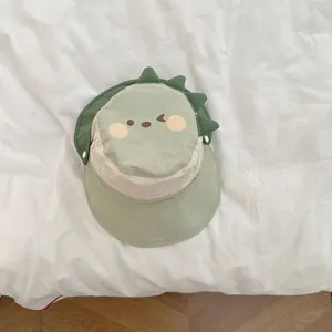 Detail of baby sun hat featuring cute green dinosaur embroidery and breathable quick-dry fabric