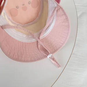 Detail of pink baby sun hat showing breathable lining with cute cartoon pattern and chin strap