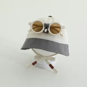 Dettaglio cappello sole traspirante per bambini con occhiali decorativi e cinturino regolabile