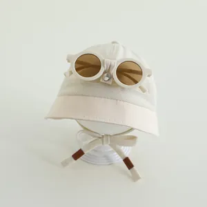 Dettaglio del cappello da sole per neonati con occhiali vintage e sottogola regolabile