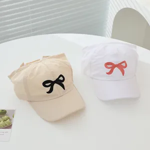 Close-up of children's sun hats with bow embroidery and breathable mesh top details