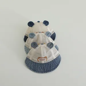 Chapeau de soleil en denim pour bébé avec oreilles et broderie ours sur fond blanc