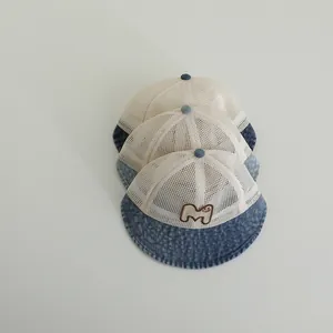 Detail of breathable mesh baby sun hat with denim brim and smiley M embroidery
