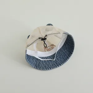 Détail du chapeau de soleil bébé en denim avec maille respirante et sangle ajustable