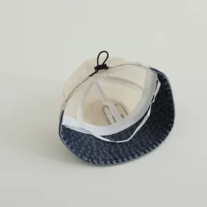 Detail of baby sun hat showing breathable mesh crown and adjustable drawstring clasp