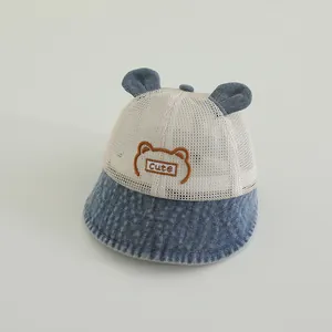 Détail d'un chapeau de soleil bébé avec filet respirant, bord denim et oreilles d'ours